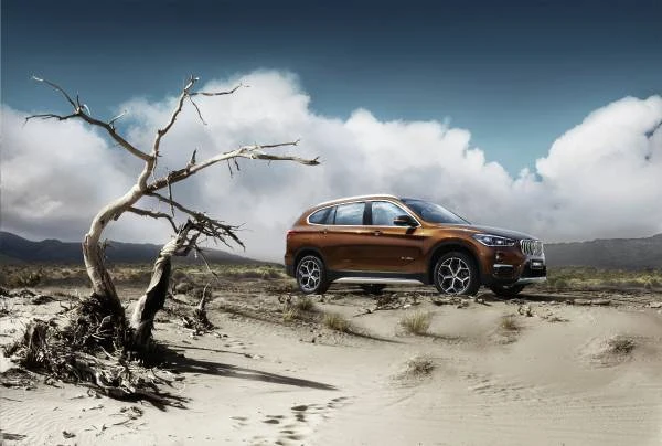 Bronze BMW X1 long-wheelbase model, side three-quarter promotional view in a landscape, 2016 reference